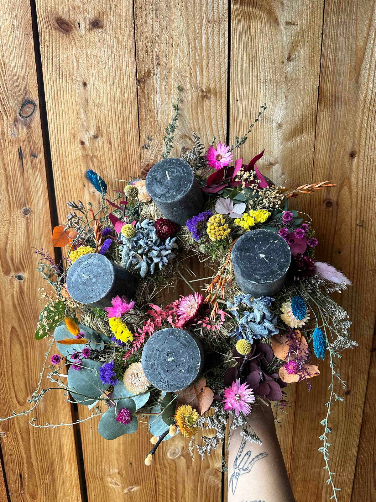 Advent wreath, colorful boho style, with dried flowers and eucalyptus – grey candles